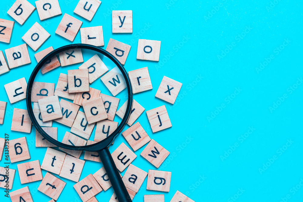 English alphabet made of square wooden tiles with the English alphabet scattered on blue background. The concept of thinking development, grammar. English alphabet made of square wooden tiles with the English alphabet scattered on blue background. The concept of thinking development, grammar.