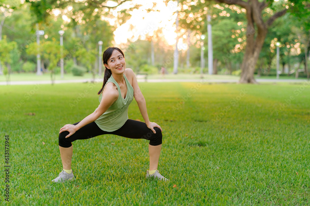 Female jogger. Fit young Asian woman with green sportswear stretching muscle in park before running and enjoying a healthy outdoor. Fitness runner girl in public park. Wellness being concept Female jogger. Fit young Asian woman with green sportswear stretching muscle in park before running and enjoying a healthy outdoor. Fitness runner girl in public park. Wellness being concept