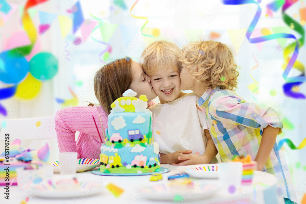 Fototapeta premium Kids birthday party. Child blowing out cake candle