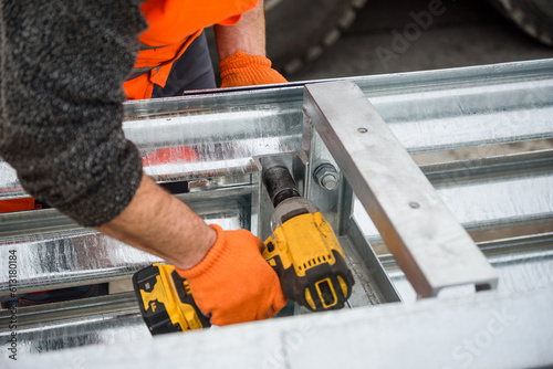 Installation of median crash barriers on highway. Metal road fencing of barrier type on freeway. Road guard rails. Safety barrier with a red and white striped sign. Protect vehicles from accidents.