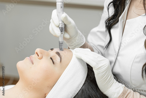 Fractional mesotherapy as an innovative method of treating facial skin, which ensures its rejuvenation and recovery, which is carried out by a professional cosmetologist in a beauty clinic. photo