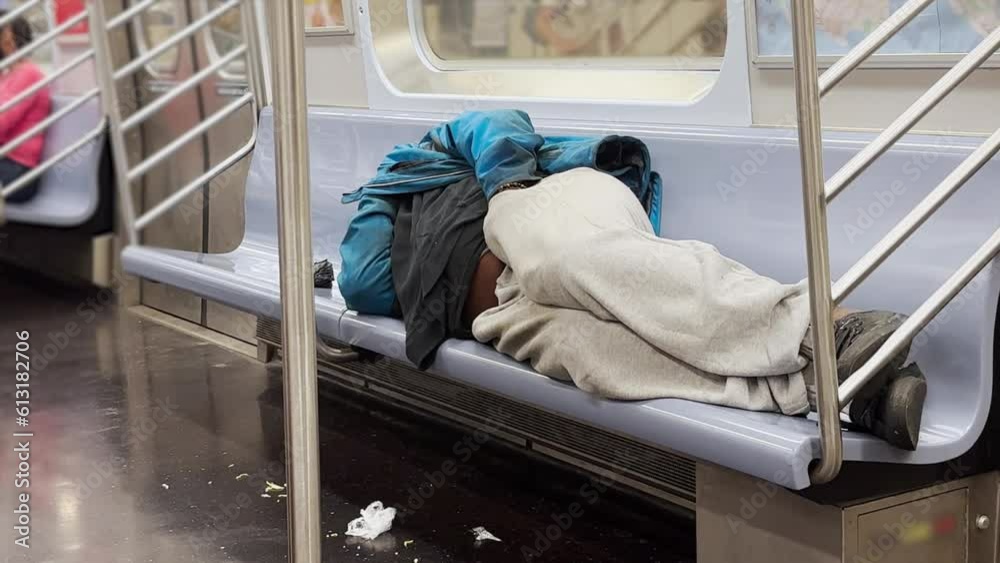 A homeless man sleeps in a Manhattan subway car.