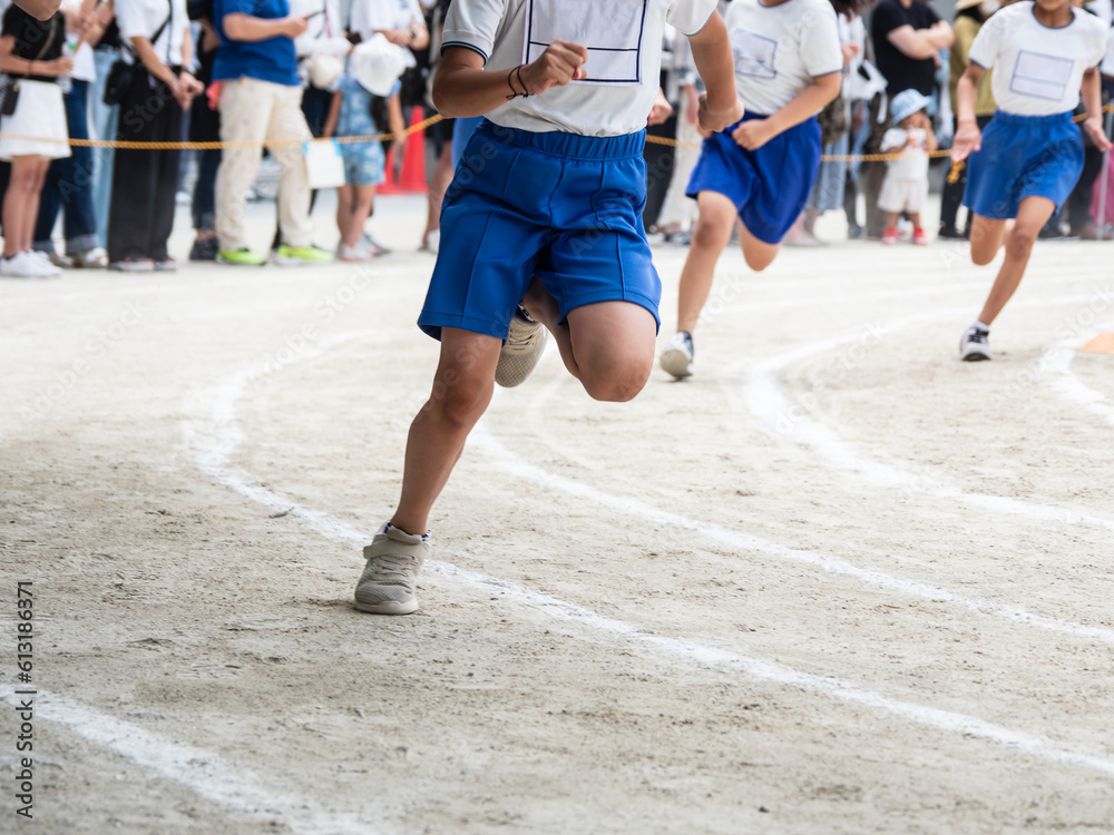 小学校の運動会でリレーを走る子供