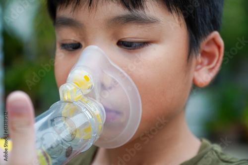 Cute Asian boy with asthma using inhaler and spacer,Inhaler, spacer and mask