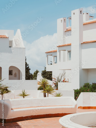 Cozy exterior or patio of the modern building with white walls, arches, windows in summer day. photo