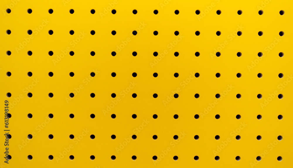 Yellow plastic perforated panel texture. Seamless tile abstract background. Pegboard. Stock