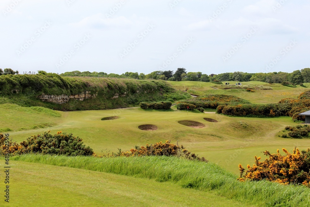 Obraz premium An incredible view of a classic links golf hole with pot bunkers in Scotland with the ocean in nearby outside of St. Andrews, Scotland