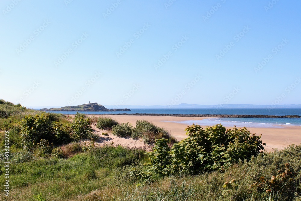 A beautiful view of the sandy coastline along the scottish coastline of North Berwick, East Lothian, Scotland. It is a sunny day with blue sky A beautiful view of the sandy coastline along the scottish coastline of North Berwick, East Lothian, Scotland. It is a sunny day with blue sky