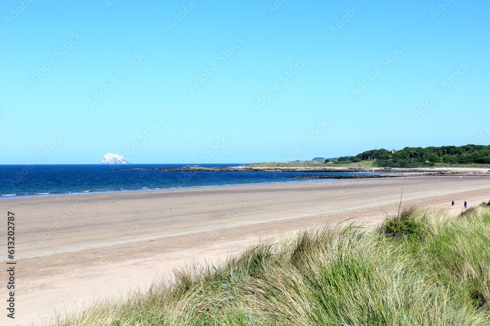 A beautiful view of the sandy coastline along the scottish coastline of North Berwick, East Lothian, Scotland.  It is a sunny day with blue sky