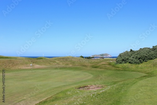 An incredible view of a golf hole in Scotland with the ocean in the background in North Berwick, East Lothian, Scotland