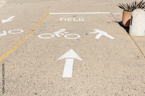 Road markings at an intersection along a path for cyclists and pedestrains alike in downtown district on a sunny day photo