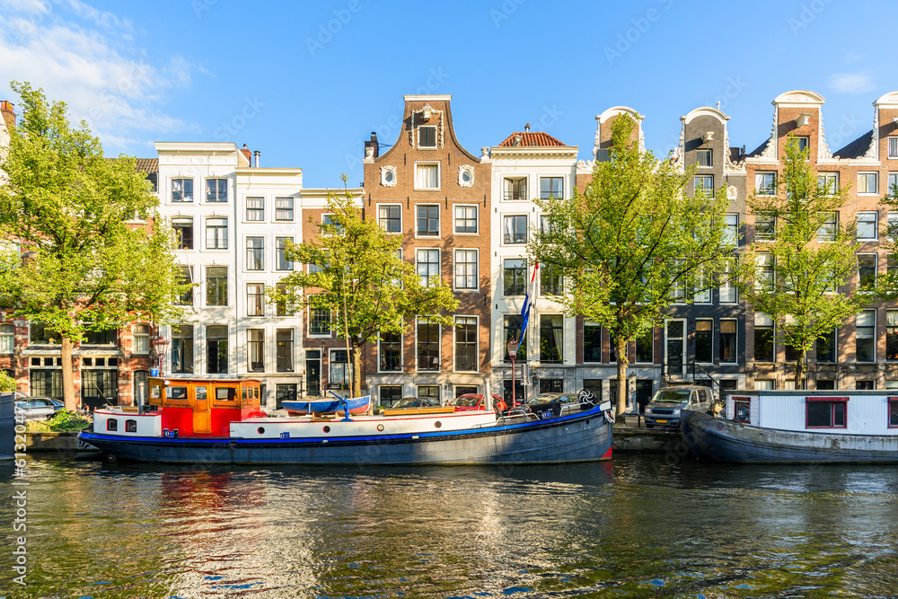 Traditional dutch architecture along a canal in Amsterdam at sunset in summer