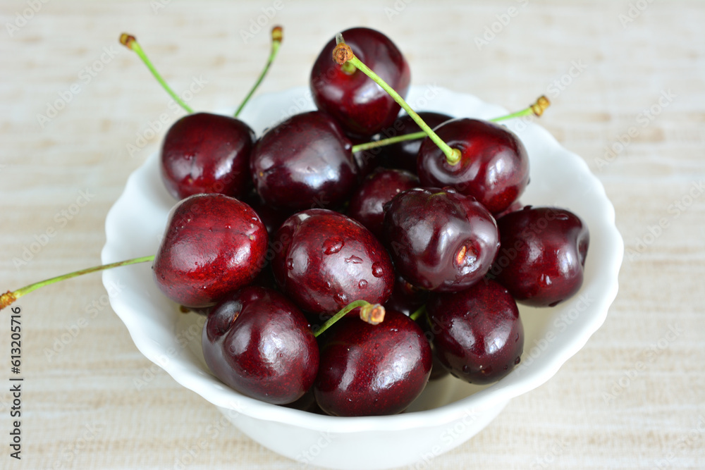 cherries with water drops isolated in white bowl, close up cherries with water drops isolated in white bowl, close up