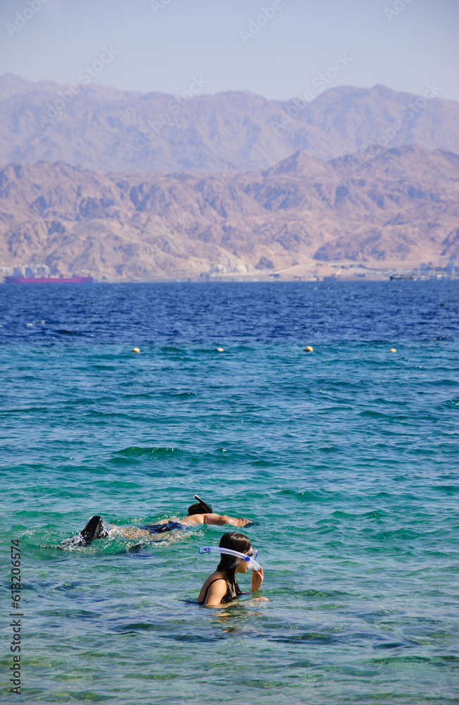 Father and daughter (unrecognizable) snorkeling at Coral Beach in Eilat, Israel. Coral Beach Nature Reserve, one of the most beautiful coral reef in the world, is famous tourist and diver attraction