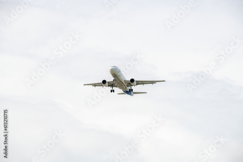 Airplane cargo or commercial take off flying high above white clouds backgroung.
