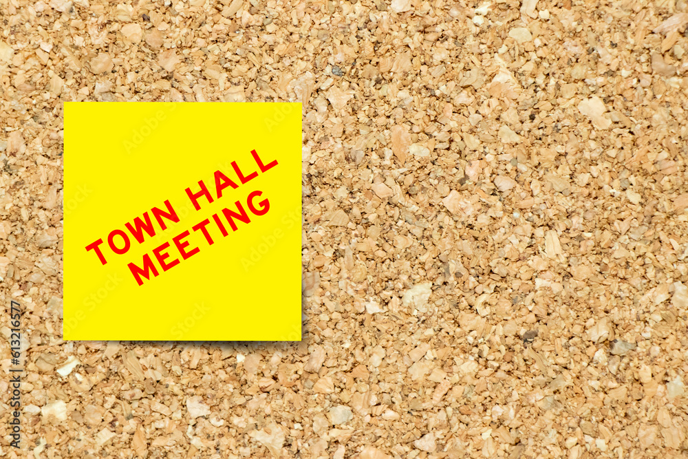 Yellow note paper with word town hall meeting on cork board background with  copy space Stock Photo