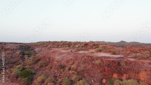Aerial shot of two friends running on hill near Bhuj, Kutch, India. People enjoying vacation. Kutch's dry landscape during summer season. photo