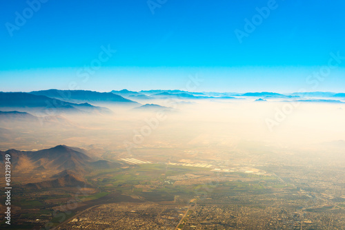 Aerial view of Santiago de Chile under a layer of smog trapped between the hills.