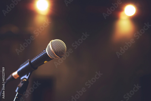 Close up of microphone on stage lighting at concert hall or conference room. copy space banner. soft focus.