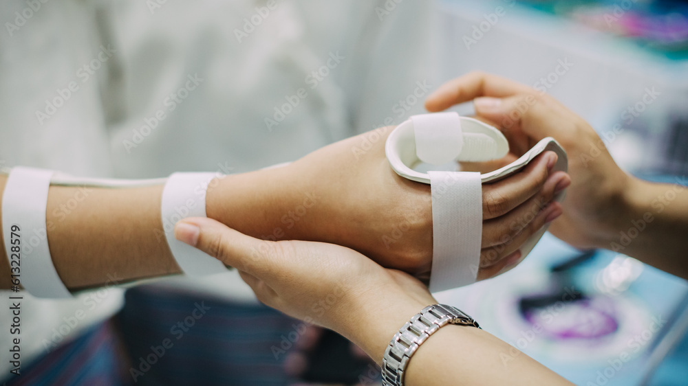Fototapeta premium Therapist making asissistive device for immobilize patient hand. Splint service for hand injury rehabilitation of occupational therapy clinic.