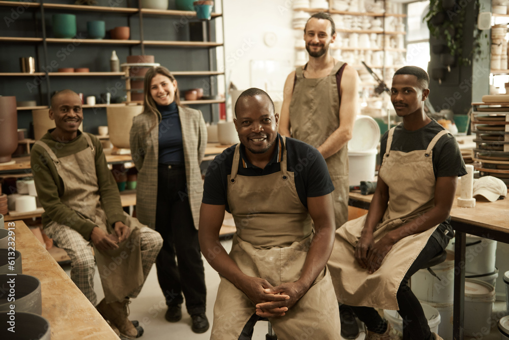 Smiling group of diverse ceramists working in a pottery studio Smiling group of diverse ceramists working in a pottery studio