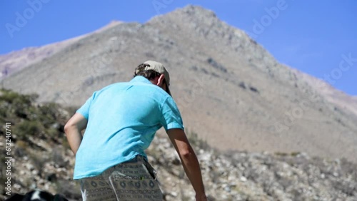 Caucasian man helps Latin American woman climb the hill photo