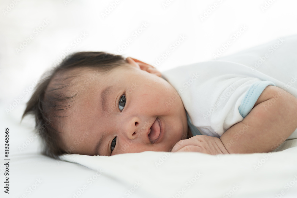 Newborn baby sleeping on blanket on white bed. Infant lying on white bed. Asian newborn baby sleeping in prone position. Asian infant Newborn baby sleeping on blanket on white bed. Infant lying on white bed. Asian newborn baby sleeping in prone position. Asian infant