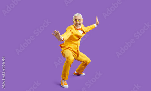 Obraz na płótnie Funny senior man in yellow suit pretends like he knows martial arts