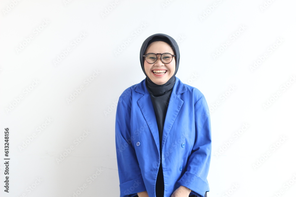 Young beautiful Asian Muslim woman, wearing glasses and blue blazer with happy smiling face expression Young beautiful Asian Muslim woman, wearing glasses and blue blazer with happy smiling face expression