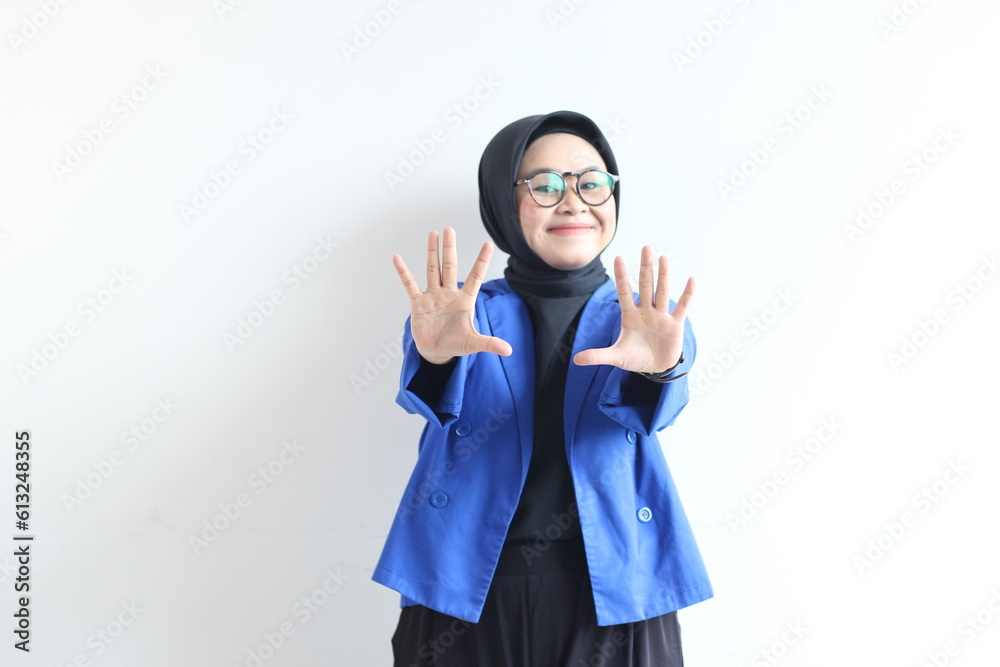 Beautiful young Asian Muslim woman, wearing glasses and blue blazer showing palms while smiling Beautiful young Asian Muslim woman, wearing glasses and blue blazer showing palms while smiling