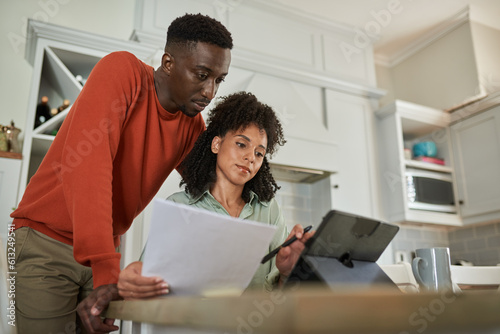 Fototapeta Young multiracial couple using a tablet to do their online banking