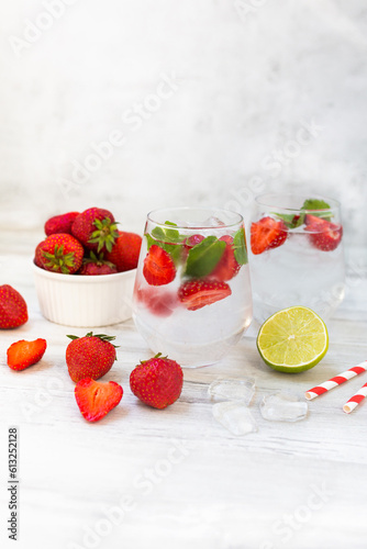 Water with strawberry, mint and lime. Ice cold summer cocktail or lemonade in glass. Detox and diet.
