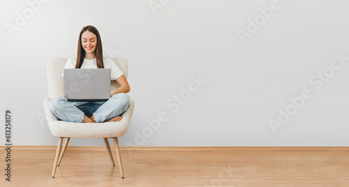 woman holding laptop computer while sitting on a chair web banner
