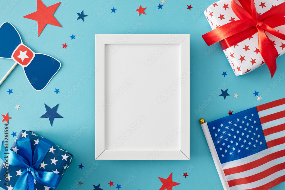 Obraz premium July 4th celebration theme concept. Top view composition of gift boxes in national colors, American flag and blue red stars on light blue background with blank frame for greeting or ad