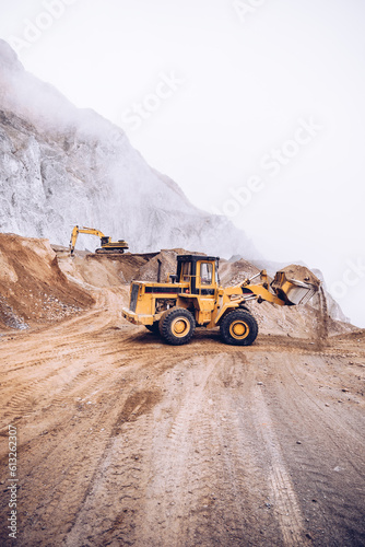 loader and excavator at work in a stone quarry