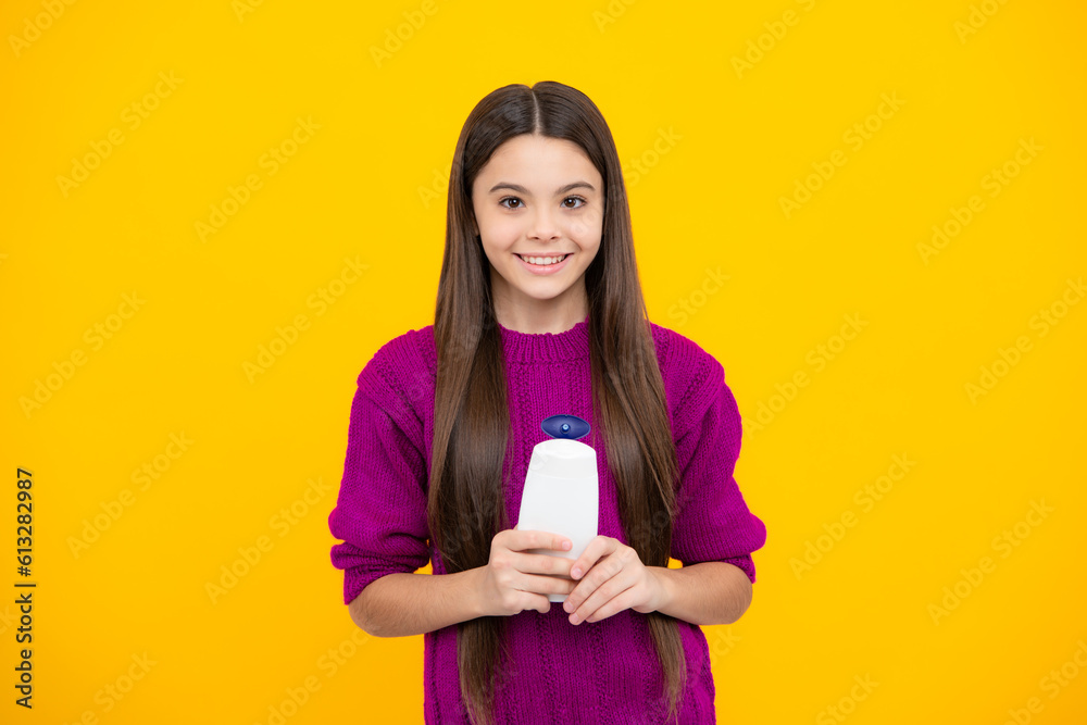 Teenager child girl showing bottle shampoo conditioners or shower gel isolated on yellow background. Hair cosmetic product. Mock up bottle. Teenager child girl showing bottle shampoo conditioners or shower gel isolated on yellow background. Hair cosmetic product. Mock up bottle.