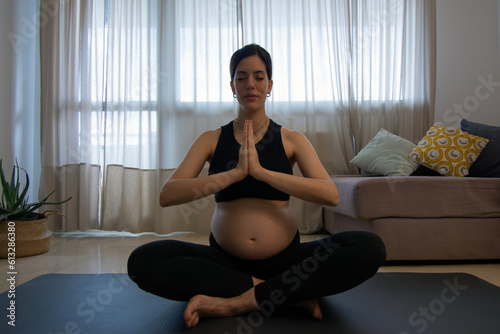 Beautiful pregnant woman practicing yoga at home