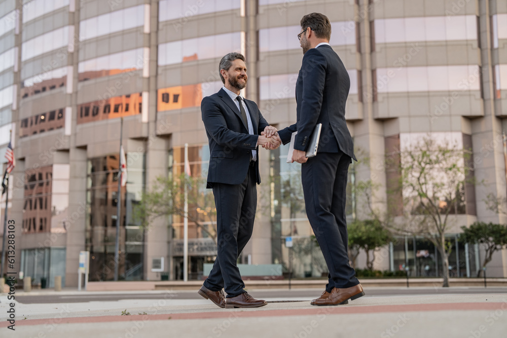 cheerful two business men handshaking. two business men handshaking outdoor. cheerful two business men handshaking. two business men handshaking outdoor.