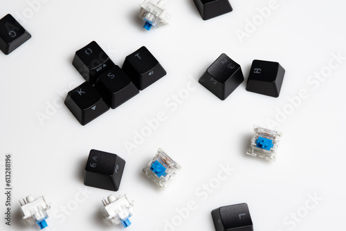 Keycaps and Keyswitch for Mechanical Keyboards Scattered on White Background
