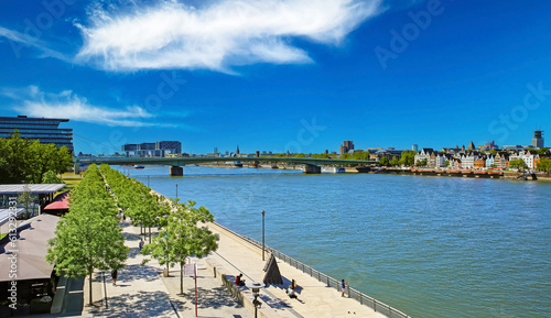 Cologne (Köln Deutz, Kennedy-Ufer), Germany - June 6. 2023: Beautiful rhine bank riverside boardwalk, Deutzer bridge, sunny summer day