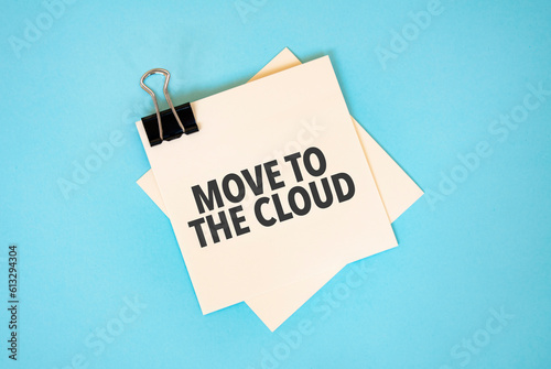 Text MOVE TO THE CLOUD on sticky notes with copy space and paper clip isolated on red background.Finance and economics concept.
