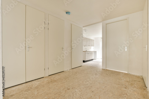 an empty room with white closets and doors on either side, looking towards the entrance to the living room