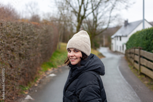 Portrait of a smiling young woman walking in the countryside in winter