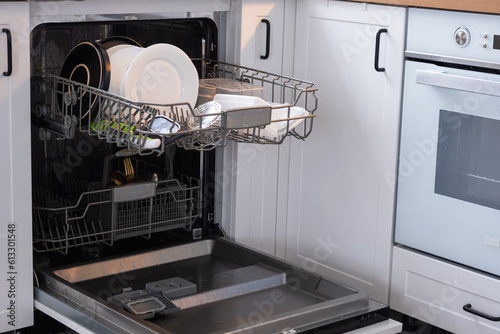 A lot of dirty dishes in the dishwasher. Helping the hostess, economy and ecology. Cleaning in the kitchen 