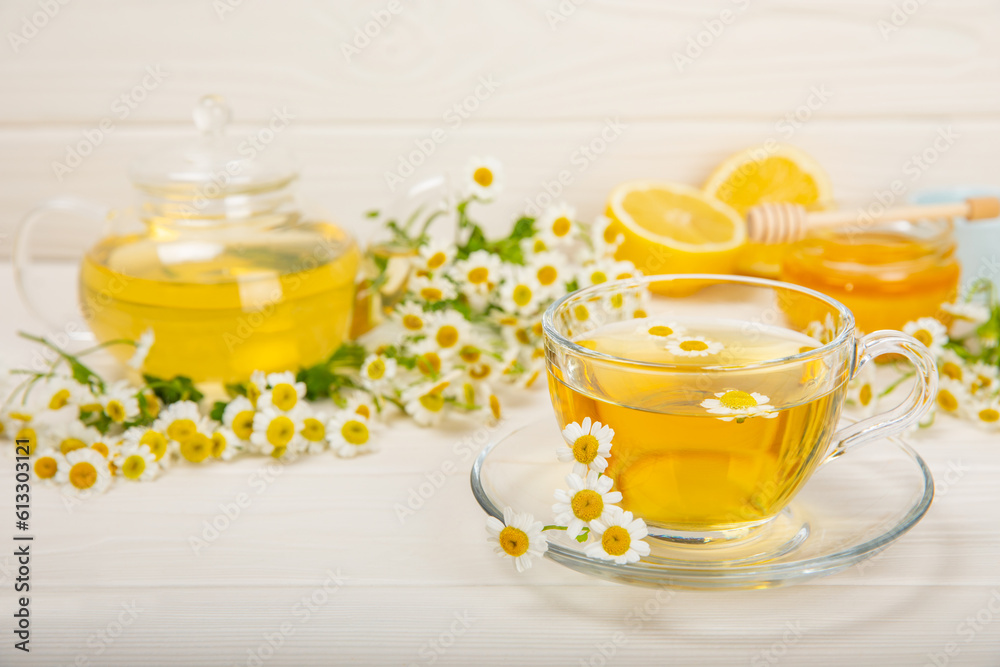 Chamomile tea in a glass cup on a white texture background. Natural hour with chamomile flowers. Herbal tea. Immunity tea.Natural healer concept. Healthy detox drink.Close up. Place for text.