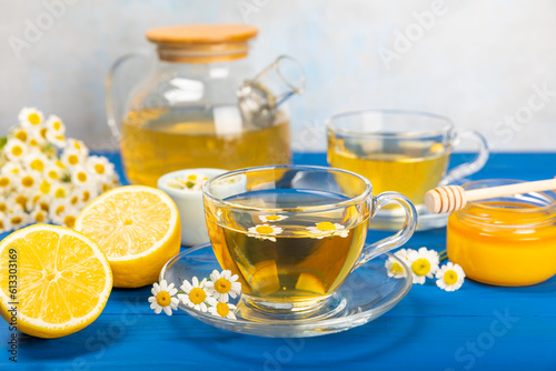 Chamomile tea in a glass cup on a blue textured background. Natural hour with chamomile flowers. Herbal tea. Immunity tea.Natural healer concept. Healthy detox drink.Close up. Place for text.