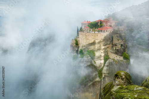 Meteora Varlaam Monastery rising out of the mist. Aerial, mystical panoramic landscape. A UNESCO World Heritage Site. Greece.