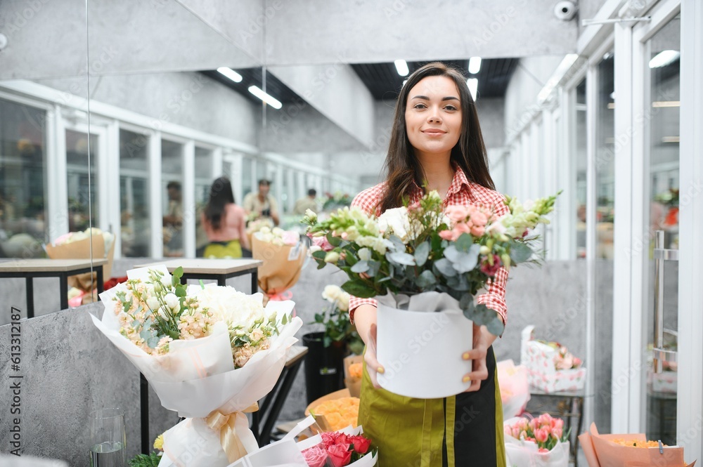 Beautiful young florist in flower shop