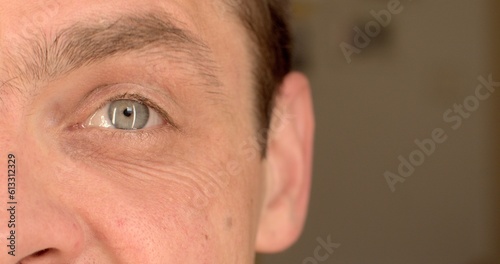 Close-up of the man's left eye raises lowers an eyebrow. Element of manifestation of emotion on the face. Glare in the pupil.