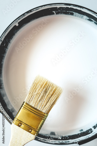 Paint brush resting on paint tin viewed from above